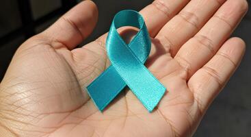 world day ovarian world, Teal Ribbon in Palm of Hand photo