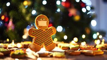 Cookie man in a mask stands on a table under falling snow video