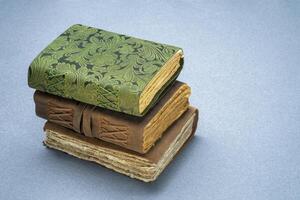 stack of retro journals with decked edge handmade paper pages, journaling concept photo