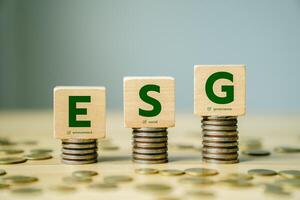ESG Concept with Wooden Blocks on Coin Stacks Representing Environment, Social, and Governance Principles for Sustainable Investment and Corporate Responsibility photo
