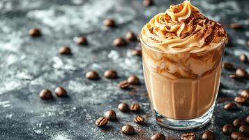 Iced dalgona coffee with creamy whipped topping served on a grey surface with coffee beans scattered around photo