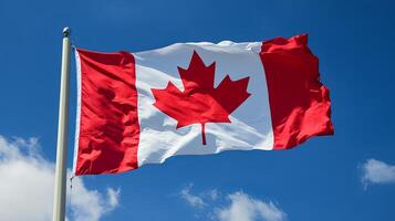 Canadian flag fully unfurled and waving in the wind under a blue sky, representing strength, pride, and unity. photo
