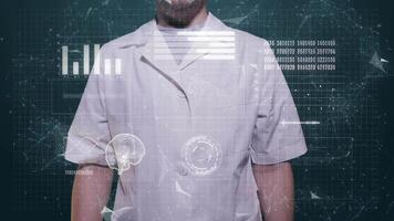 A man in a white coat stands in front of the screen and gestures video