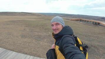 A man taking a selfie with a camera on a boardwalk video