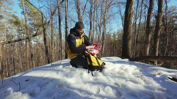 A man sitting on the snow with a backpack video