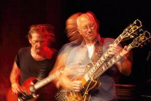 Dynamic performance of musicians at live concert with electric guitars in vibrant setting photo