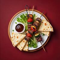 Delicious skewers of meat and vegetables served with fresh bread and sauce photo