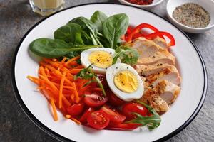 Healthy salad with chicken, boiled eggs, and assorted vegetables in a vibrant display photo
