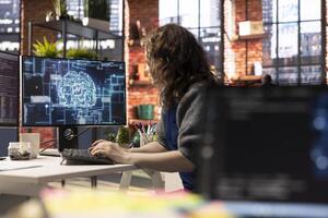 Teleworking developer using computer for artificial intelligence computing through self learning algorithms. Agency IT engineer works with AI deep neural networks on desktop PC. photo