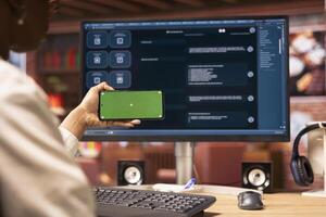 Woman using mockup smartphone to look at tutorials on AI chatbots in home office. Person holding green screen phone to look at visual guides on artificial intelligence LLMs photo