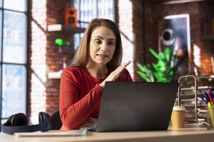 Woman focused on a virtual workshop to learn new skills remotely, interacting with the tutor on call. Ambitious person attend an interactive learning session for personal development. photo