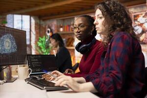 Team of programmers in artificial intelligence focused startup overseeing worker designing, coding and debugging applications. Teamworking colleagues doing code testing and quality assurance photo