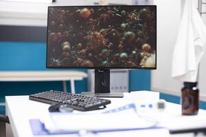 Closeup on computer screen displaying cellular structures related to flu disease, highlighting technology used for biological research. Modern desktop pc clinic office desk shows image of viral cells. photo