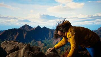Clumsy hiker tripping and falling off of a mountain peak cliff, leading to an accident due to lack of attention. Inconsiderate unprepared traveler stumbles on unstable terrain. Camera A. photo