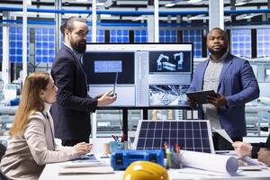 Shareholders meet with solar panels plant managers to ask technical questions. Investors doing due diligence before investing in photovoltaics factory, evaluating production processes efficiency photo