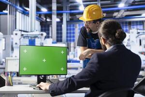 Photovoltaics factory colleagues doing brainstorming to optimize production flow using mockup PC. Solar panels plant experts in office monitoring manufacturing process on green screen computer photo