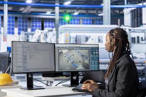Software developer typing code on PC in photovoltaics production facility, building software tools. System administrator developing automation routines on computer to enhance system efficiency photo