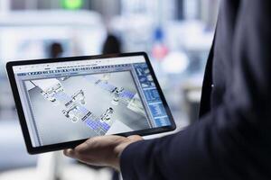 Technician using tablet to monitor solar panel plant assembly lines. Close up of employee using touchscreen device to troubleshoot photovoltaic equipment, ensuring seamless production workflow photo