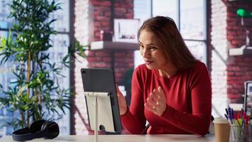 Excited woman joining online lesson to work on new skills from home desk, attending web conference call and watching lecture from her loft. Adult participates at a virtual training class. Camera A. photo