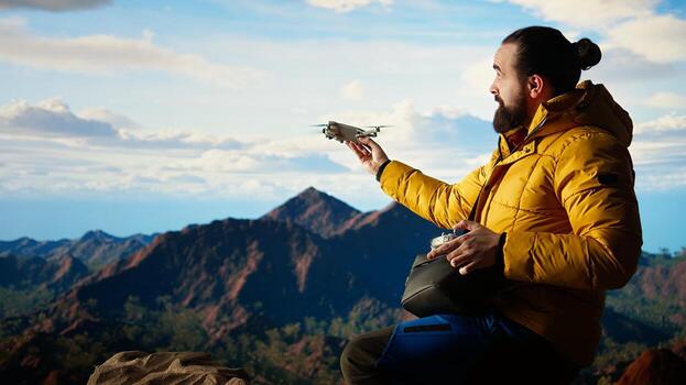 Trekking enthusiast captures his activity on using a drone footage, documenting the scenic mountain range valley. Filming beautiful aerial view vlog with remote control device. Camera A. photo