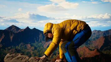 Hiker underestimates the power of mountain winds and slipping on rocks, causing an accident and risking his life. Young unprepared climber tripping from a mountain top, losing balance. Camera A. photo