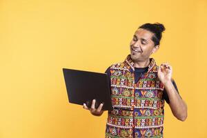 Happy software engineer remotely solving bugs for client over internet videocall on notebook. Cheerful IT technician discussing with customer on online videoconference, studio background photo
