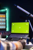 Artistic designer using advanced tools for photo retouching next to chroma key at home office, representing the flexibility of a creative career in the tech industry. Expert editing a project.