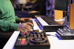 Audio technician working with a professional editing software on pc, mixing and mastering his old songs recordings in home studio. Musician uses stereo equipment and amplifier. Close up. photo