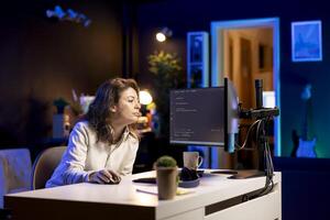 Developer typing code on computer to futureproof company network from downtimes and unexpected system failures. Woman deploying programming script increasing data security on desktop PC photo
