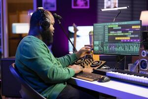 Talented engineer using an usb stick to edit recorded files in home studio, working on music post production. Young audio technician adding sound effects on mixing console and pc interface. photo