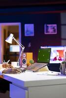 Person at home office desk using green screen mockup laptop, composing social media posts. Remote content creator employee monitoring engagement on chroma key isolated screen notebook photo