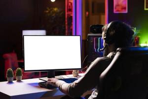 Man chatting with friends online while playing together in multiplayer game on isolated screen desktop PC, close up. Player cooperating with teammates in coop videogame using mockup monitor photo