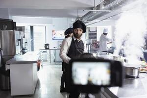 Chef recording a detailed cooking demonstration for a vlog tutorial, showcasing food preparation and gastronomy techniques. Helping remote students master fine dining culinary skills. photo