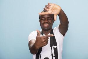 African American male filmmaker framing his shot with his fingers, forming a rectangle shape instead of using the viewfinder. Black man doing a signature hand gesture of photographers in studio. photo