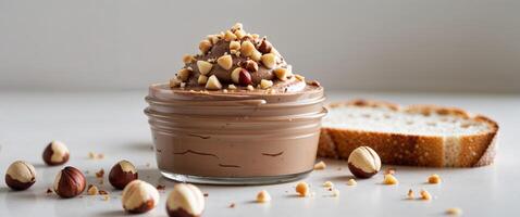 A jar of chocolate pudding with nuts and bread photo