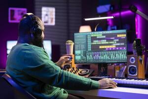 Musical engineer producing new tracks with an usb stick in home studio, editing songs from old audio files. Young sound designer mixing and mastering his recordings, professional software. photo