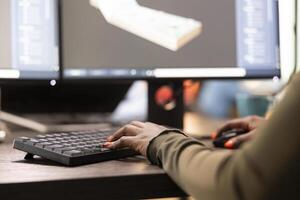 Digital artist refining geometry and sketching machinery tools using advanced design software on computer. Closeup of an african american 3D modeler improving project geometry. photo