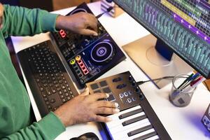 Sound engineer artist adding effects on his audio files in post production, working with a console and daw software to mix and master tunes. Musician adjusting songs volume levels. Close up. photo