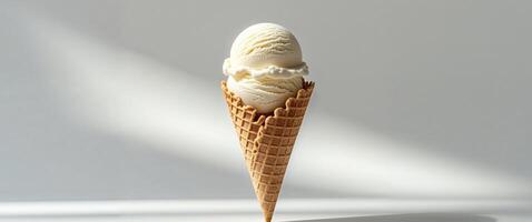 A single scoop of vanilla ice cream in a crispy waffle cone photo