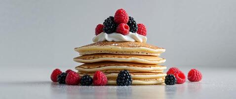A stack of pancakes with berries and cream photo