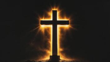Cross silhouette illuminated by golden light in a dark setting photo