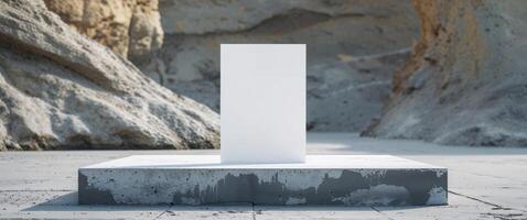 A white square on a concrete block in front of a cliff photo
