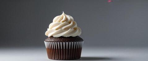 Chocolate Cupcake with White Frosting on Dark Background. photo