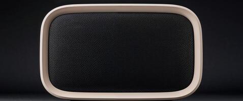 A close up shot of a modern speaker with a black mesh front and a beige frame on a black background photo