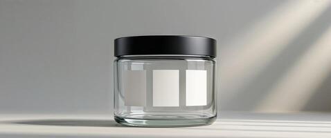 A clear jar with black lid and blank white labels on display. photo