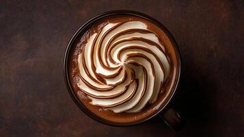 Warm chocolate beverage topped with creamy swirls and design photo