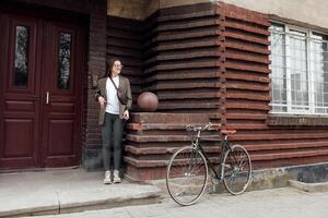 Cyclist in tweed attire enjoying a vintage bicycle ride near a retro architectural building photo