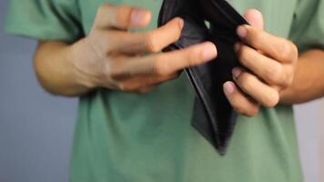 a man shows an empty wallet. a sad person because he has financial problems from a bad job and a small salary video