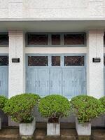 Charming facade with blue doors and neatly trimmed greenery in urban setting photo
