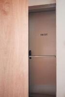 Fire exit door partially opened in a modern building hallway photo